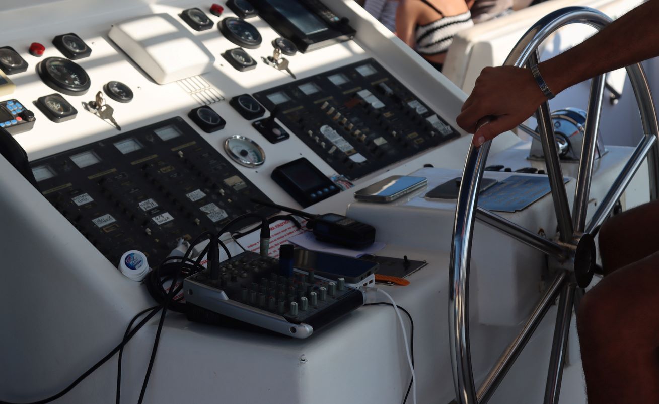 A pilot operating a boat from the Miami International Boat Show with a visible control panel and instruments